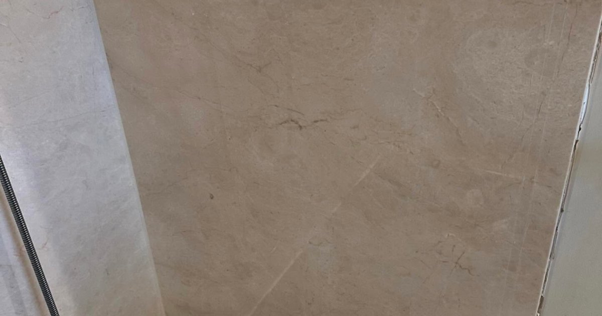 Light marble-effect wall panels in a shower area