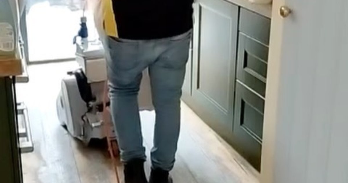 Technician sanding a wooden floor in a hallway